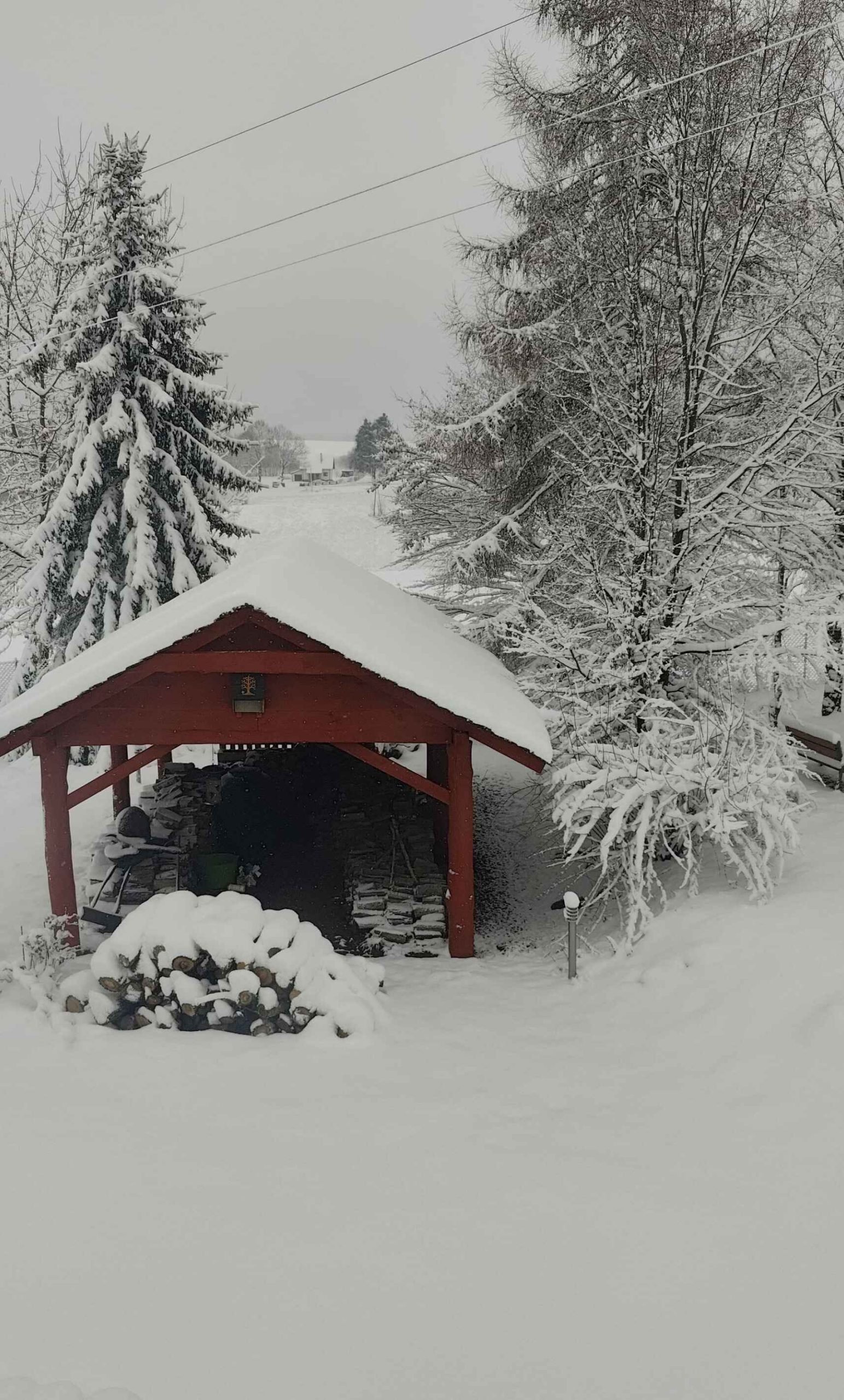 zimowy krajobraz. szopa na drewno pokryta śniegiem.